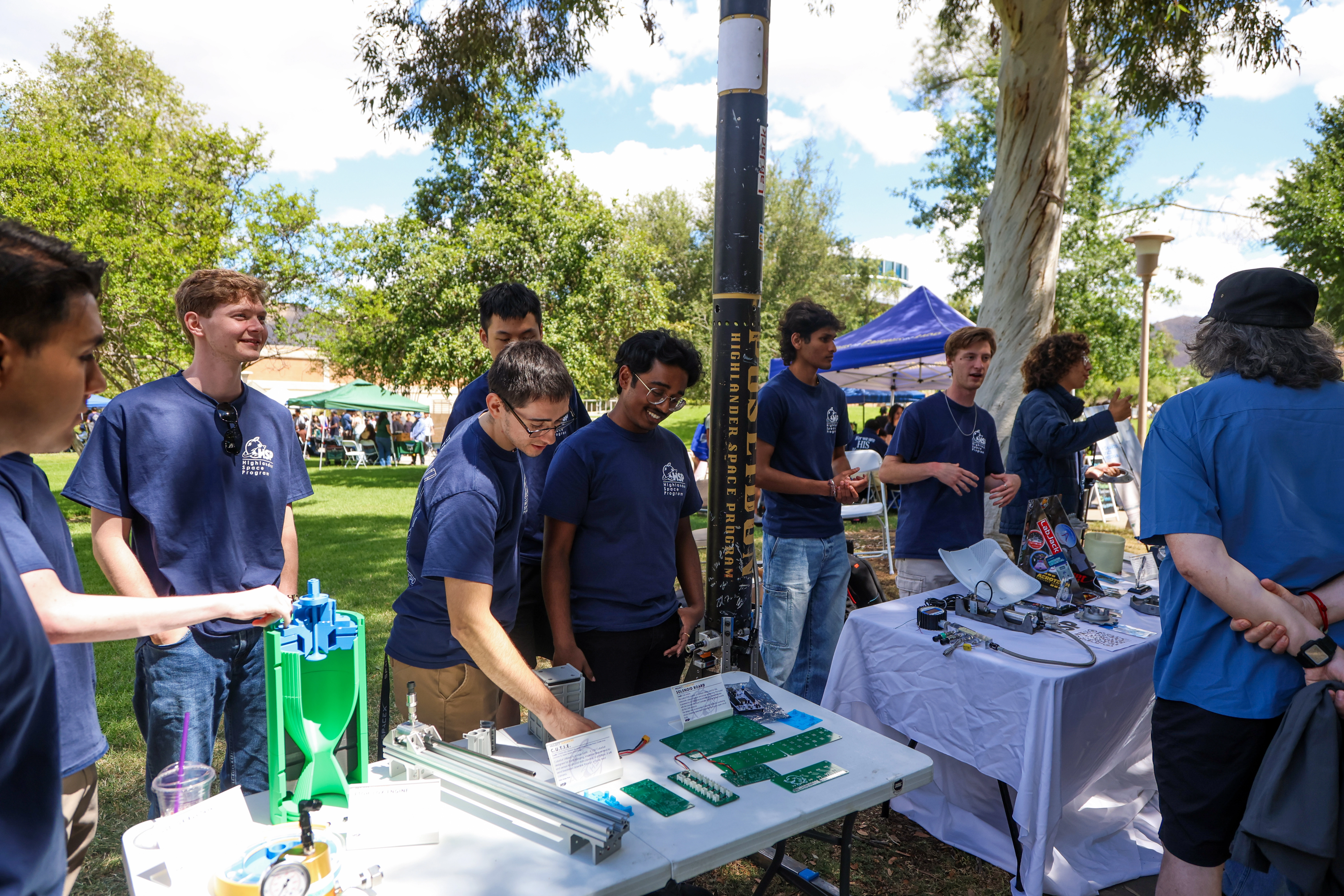 HSP members sharing rocket hardware at a campus table